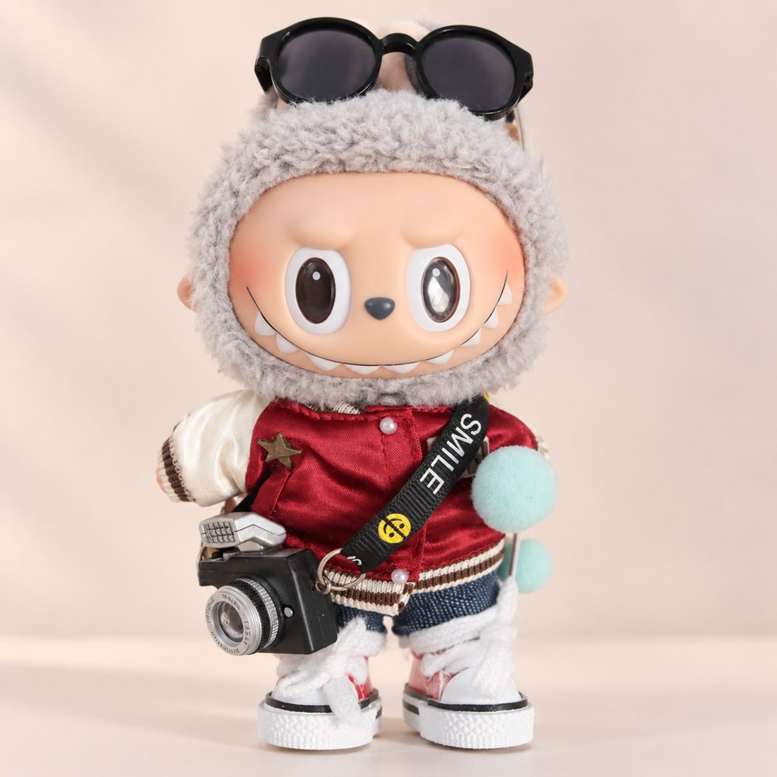 Plush doll wearing denim explorer outfit with camera and sunglasses