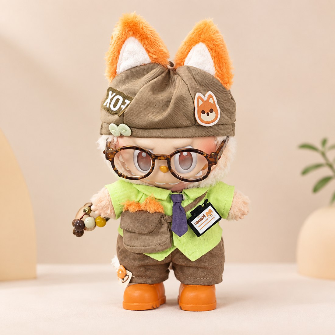 Plush doll wearing rust colored fox costume with ears