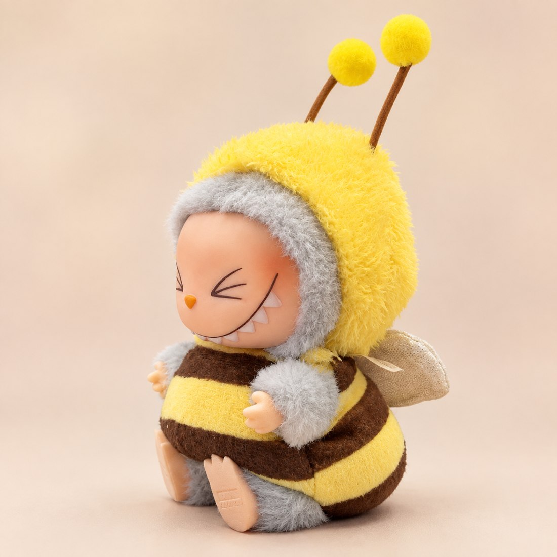 Plush doll wearing yellow black striped bee costume with wings — doll outfit for Labubu-style and cotton dolls