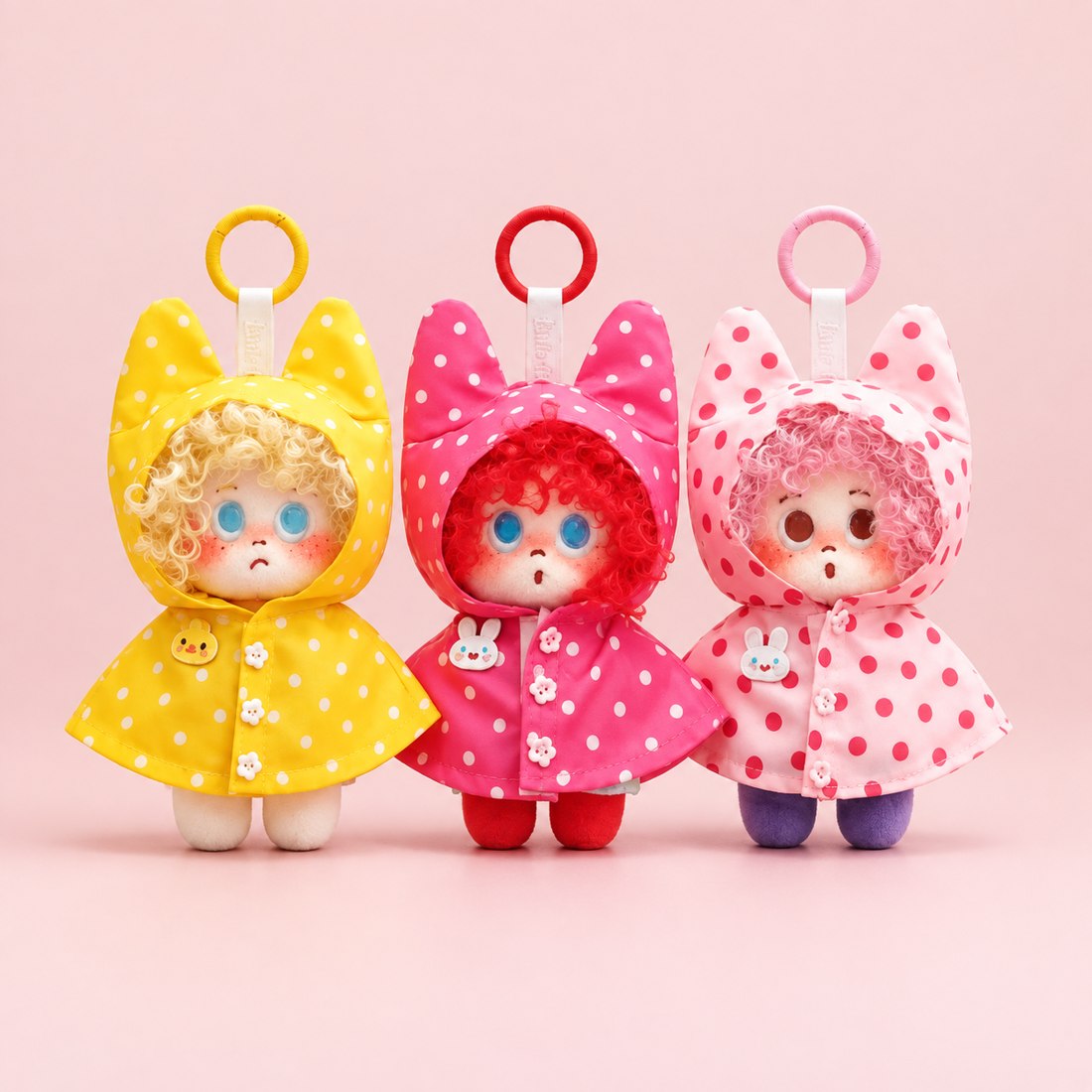 Plush doll wearing polka dot raincoat with cat ear hood