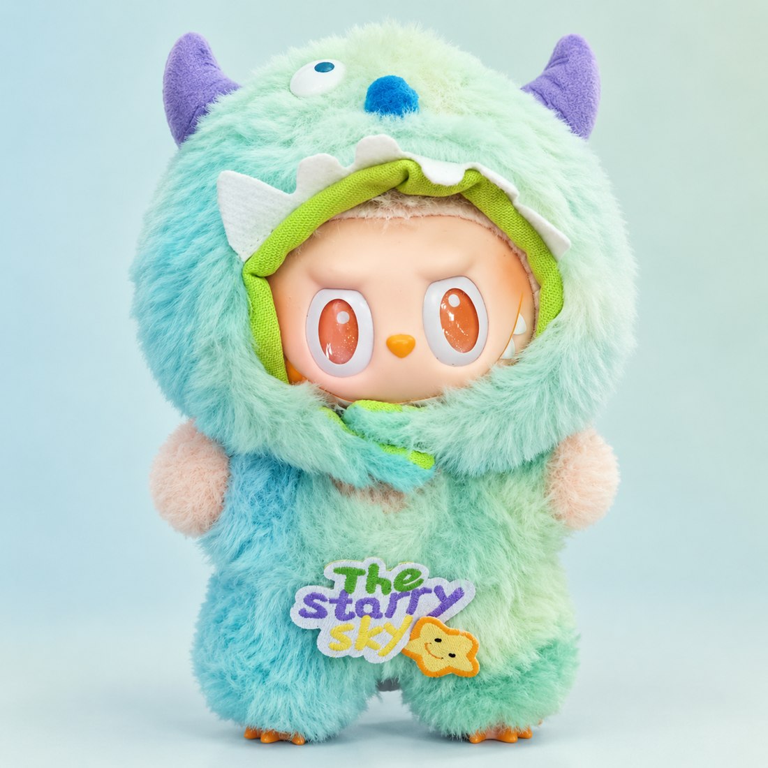 Plush doll wearing blue green gradient monster outfit with purple horns